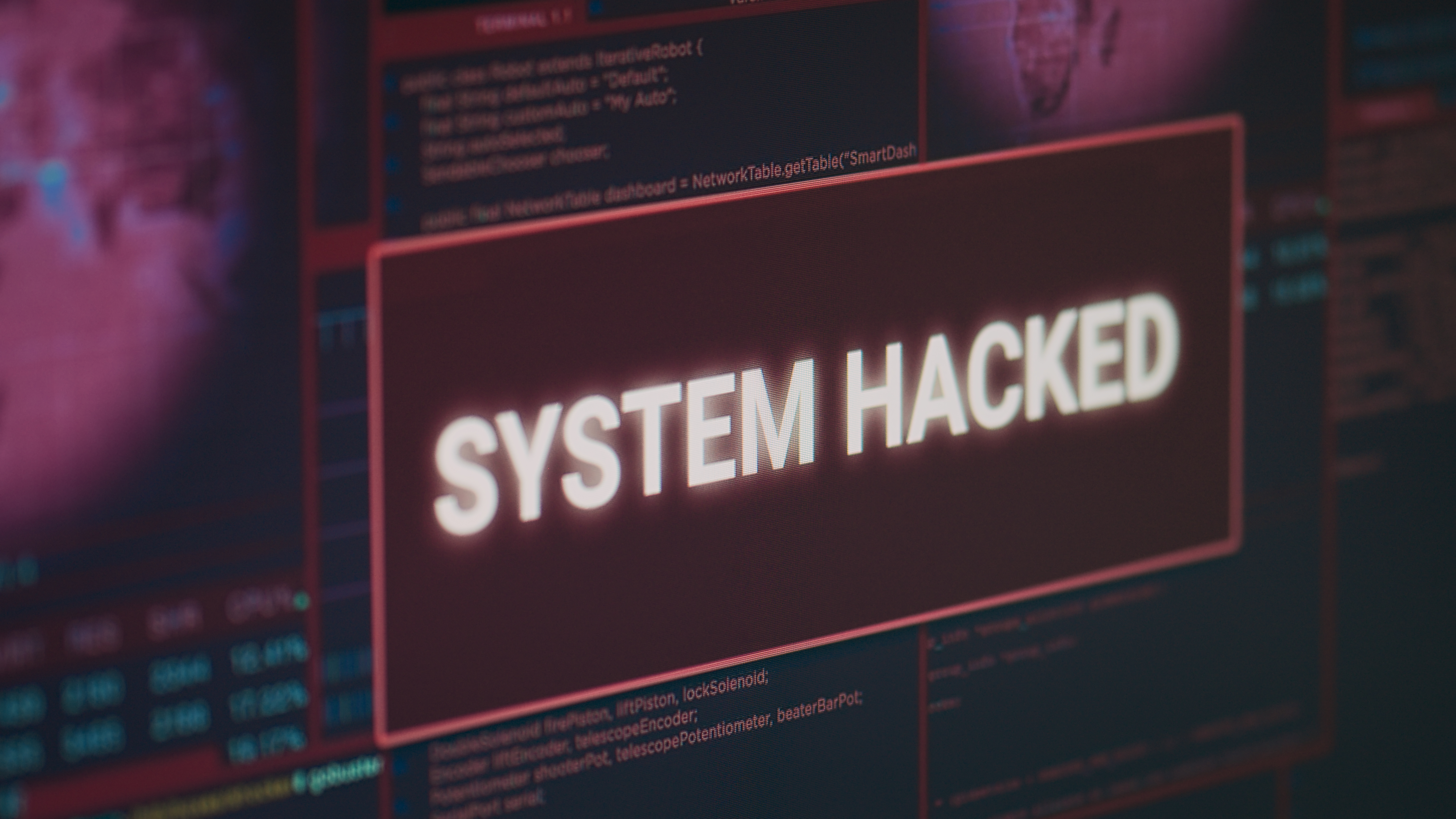 Computer monitor showing hacked system alert message flashing on screen, dealing with hacking and cyber crime attack. Display with security breach warning and malware threat. Close up.