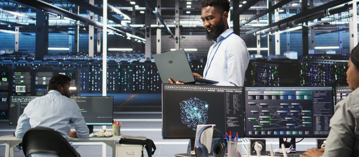 Data center programmer uses node tree software to identify equipment performance issues. African american server farm worker reviews data analysis graph to minimize hardware failures, camera A