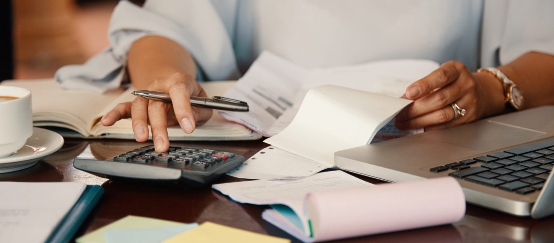 Hands of female entrepreneur working with bills and documents